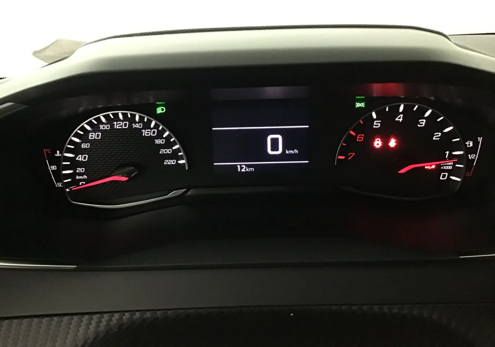 Tableau de bord du Peugeot 208 blanc 2024, affichage numérique au centre avec compteur vitesse et compte-tours éclairés.