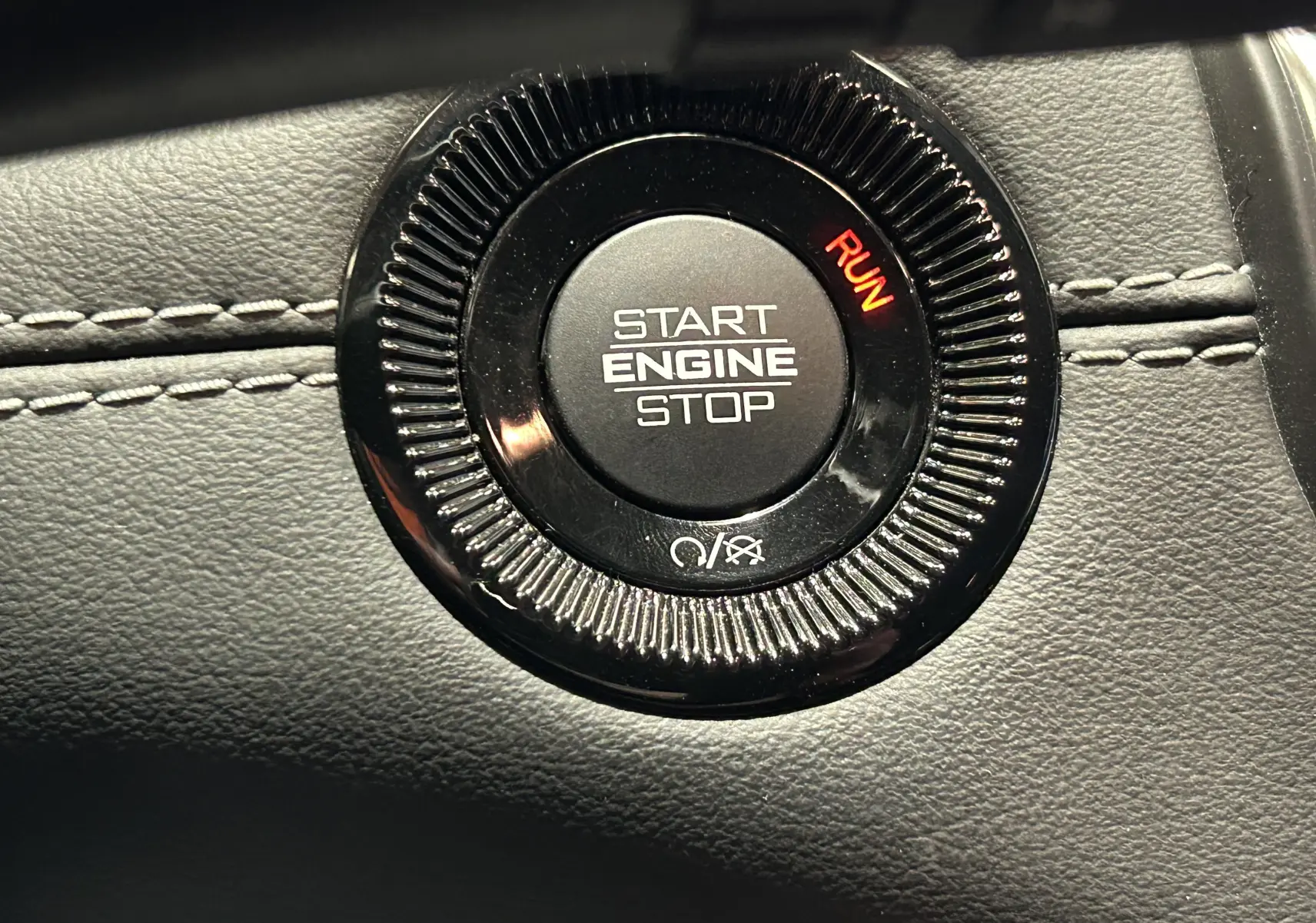 Gros plan sur le bouton Start Engine Stop noir avec indication RUN rouge, sur tableau de bord cuir gris du Jeep Compass 2021.