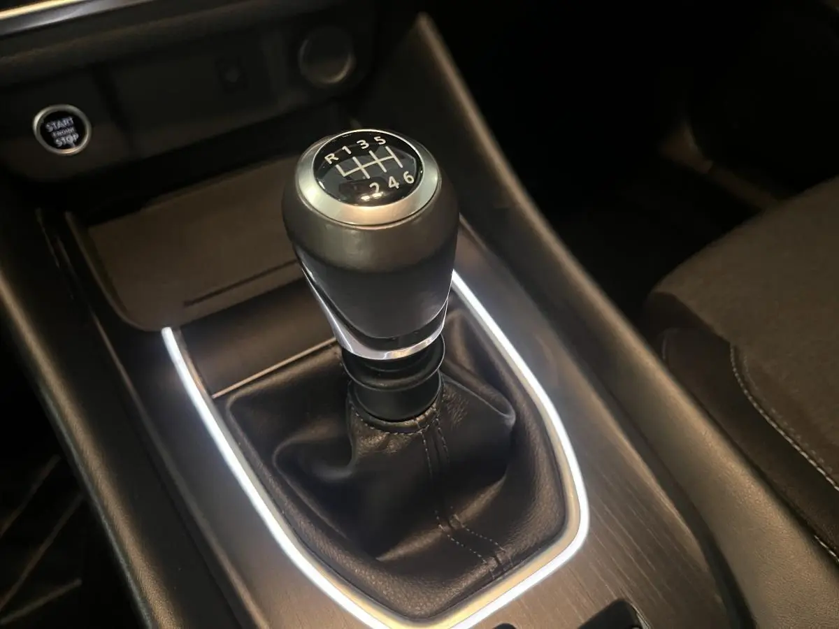 Le levier de vitesses manuel noir du Nissan Qashqai 1.3 Mild Hybrid 140 Shadow vu en gros plan sur la console centrale.