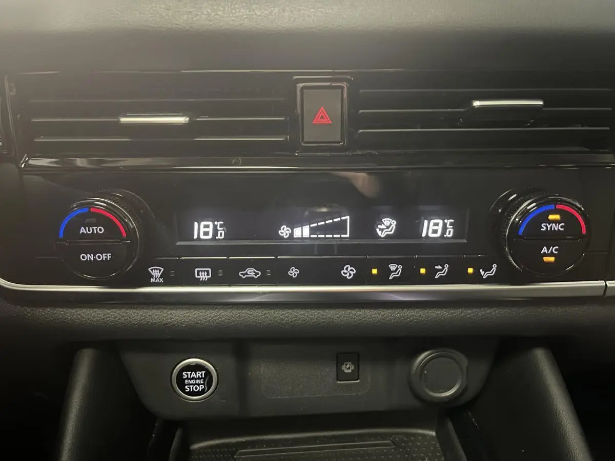 Vue rapprochée de la console centrale du Nissan Qashqai 2024 avec climatisation bi-zone et bouton Start/Stop.