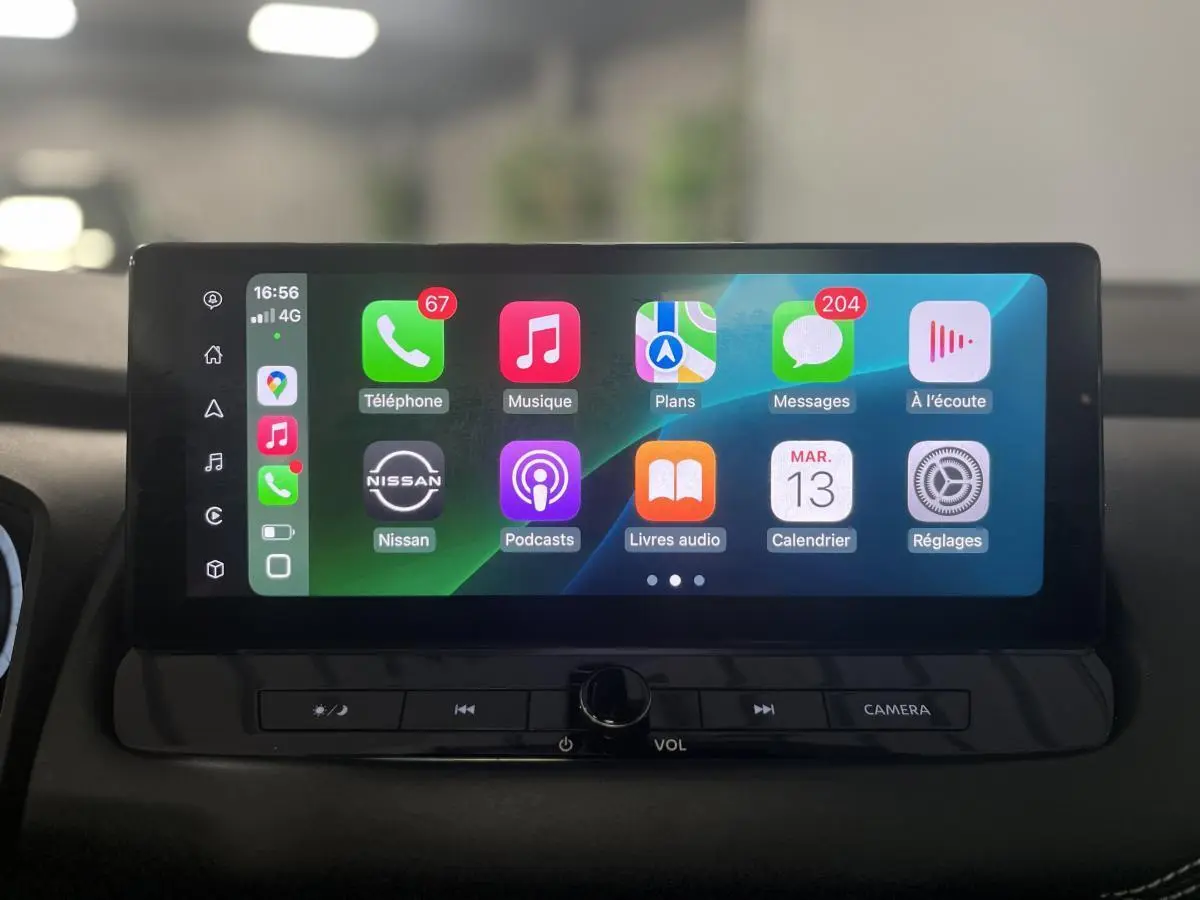 Écran tactile central du Nissan Qashqai 2024 affichant Apple CarPlay avec commandes sous l'écran.