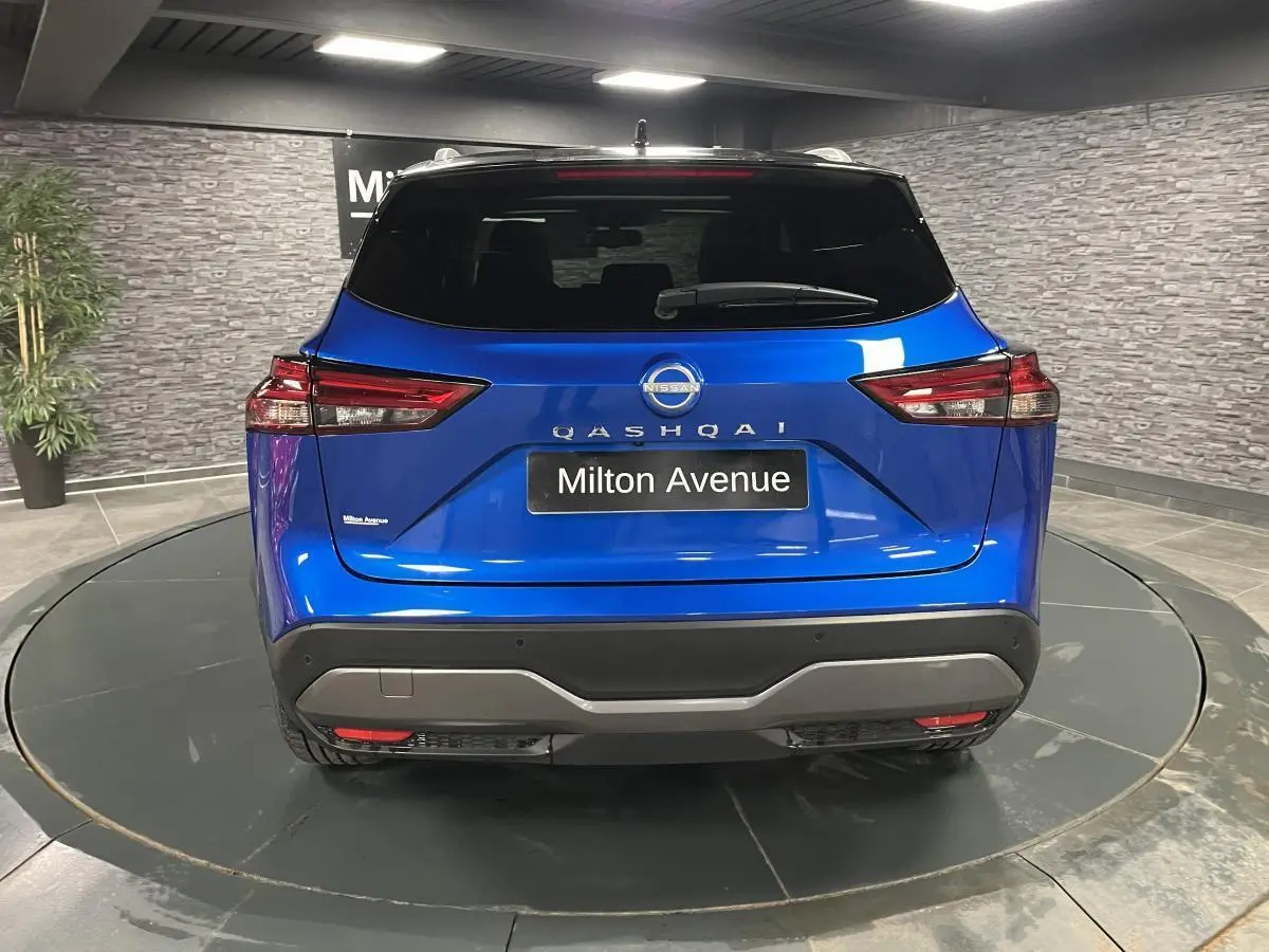 Vue arrière du Nissan Qashqai 1.3 Mild Hybrid 140 Shadow bleu avec feux LED et plaque Milton Avenue.