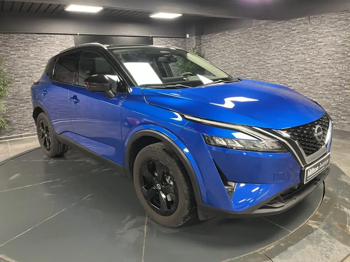 Nissan Qashqai 1.3 Mild Hybrid 2024 bleu, vue 3/4 avant droit avec jantes noires et toit noir.