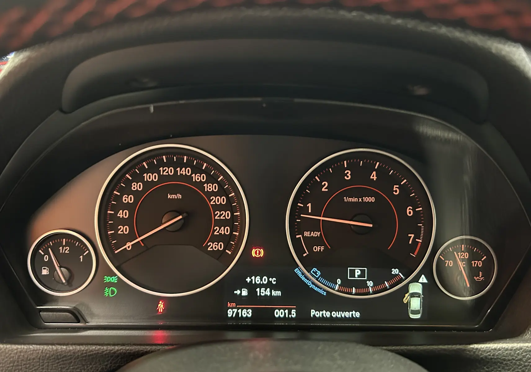 Tableau de bord de BMW Série 3 320i blanc 2018, affichant vitesse, compte-tours et alertes au centre.