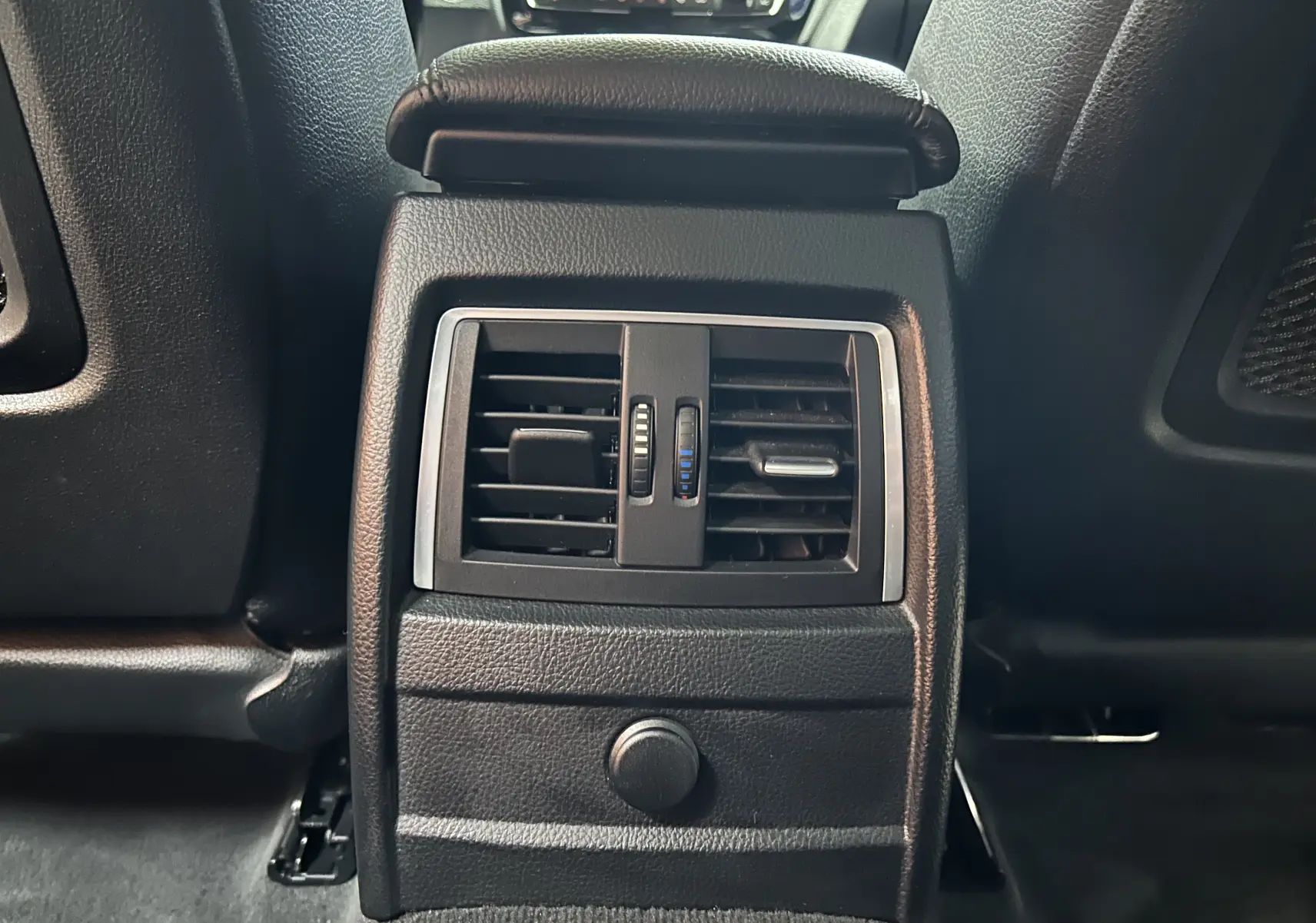 Gros plan sur la sortie d'air arrière centrale en plastique noir de la BMW Série 3 320i blanche de 2018.