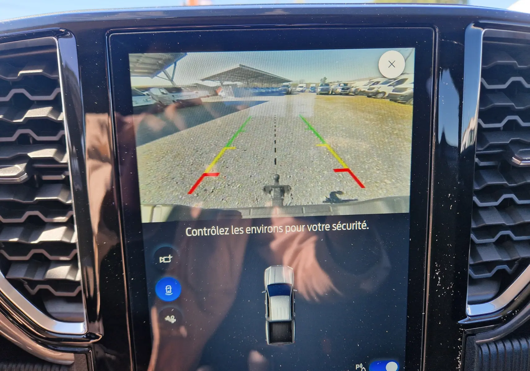 Écran de caméra de recul du Ford Ranger Super Cabine gris carbone montrant l’arrière avec lignes de guidage colorées.