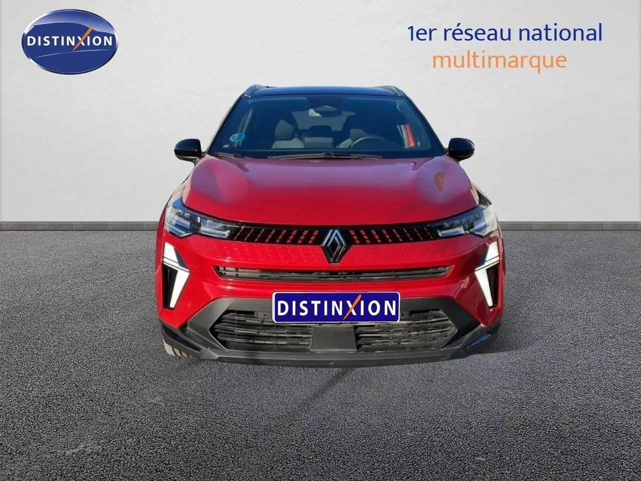 Vue de face du Renault Captur rouge Désir métal avec toit noir, mettant en valeur ses feux LED et sa calandre distinctive.