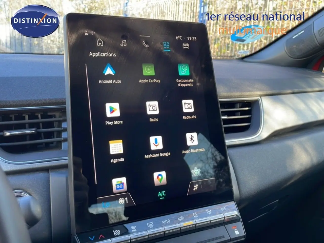 Vue intérieure centrée sur l’écran tactile vertical du tableau de bord du Renault Captur rouge Désir métal.