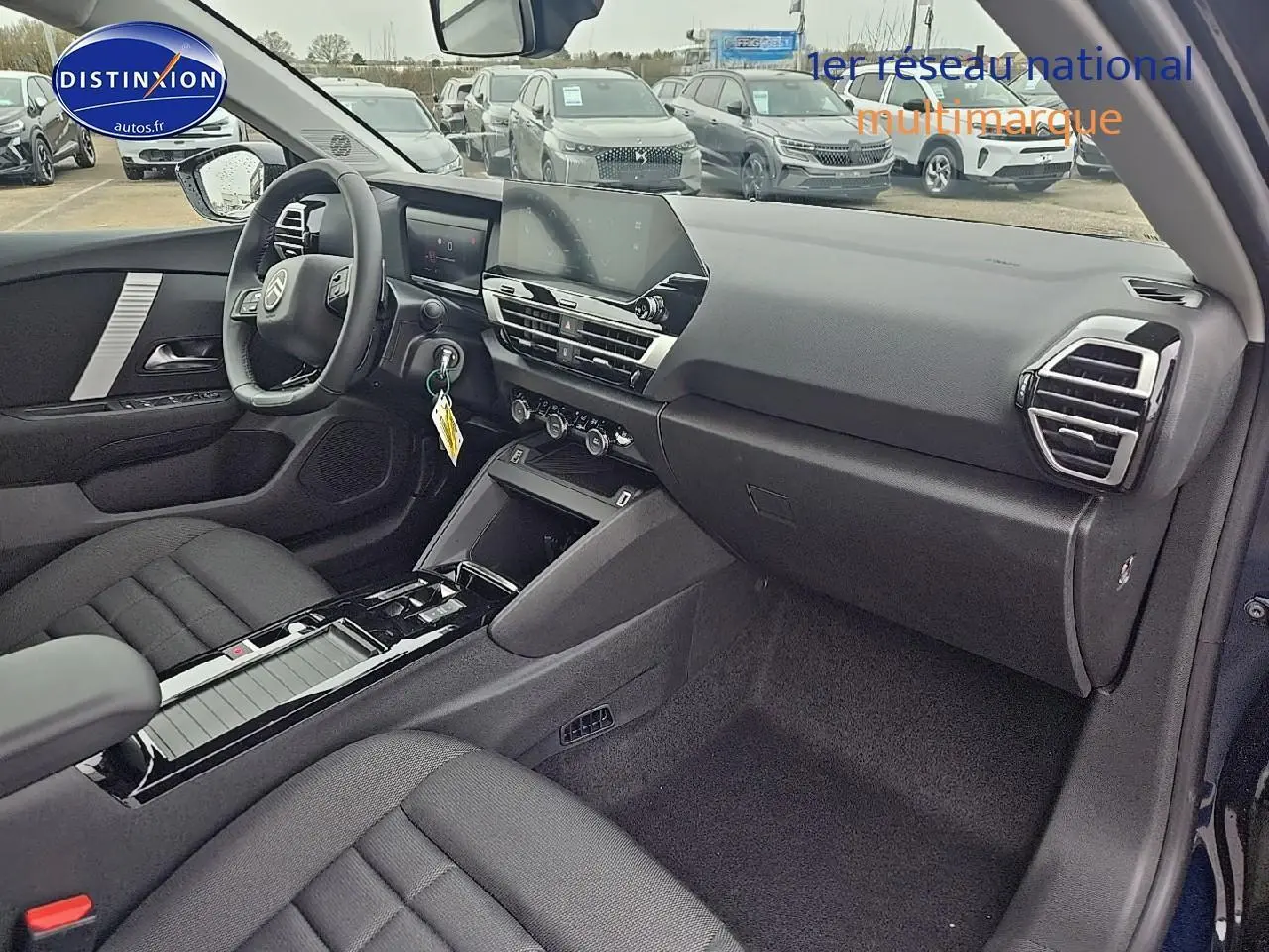 Vue intérieure côté passager de la CITROEN C4 1.2 hybride 136 noire, avec tableau de bord moderne et écran tactile central.