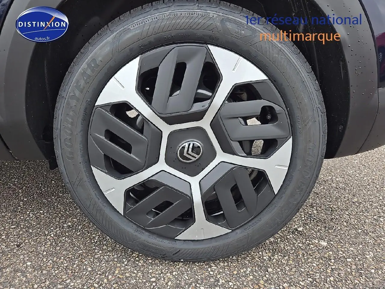 Gros plan sur la roue avant gauche noire métal de la Citroën C4 hybride avec jante alliage 18 pouces bicolore.