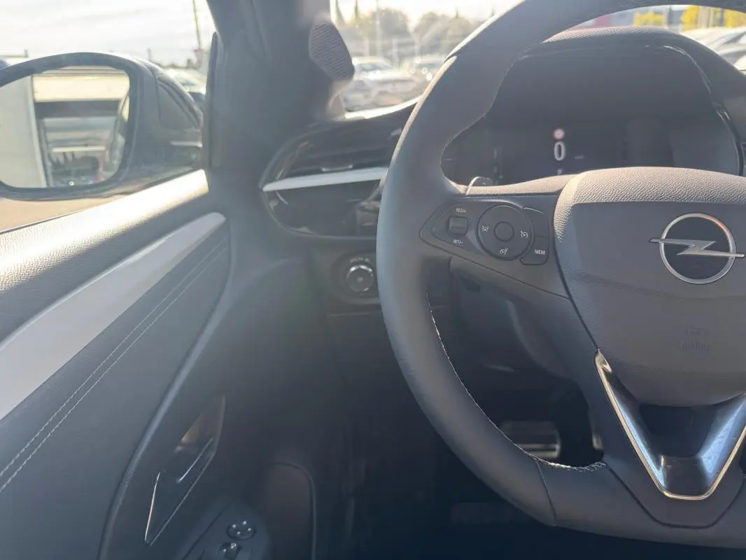 Vue intérieure côté conducteur de l’Opel Corsa rouge 2025, avec volant multifonction et tableau de bord digital.