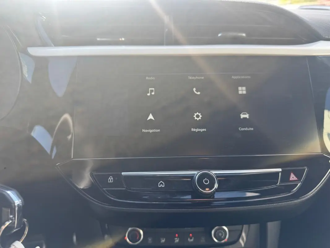 Vue rapprochée de l’écran tactile central de l’Opel Corsa rouge 2025, affichant les menus radio, navigation et réglages.