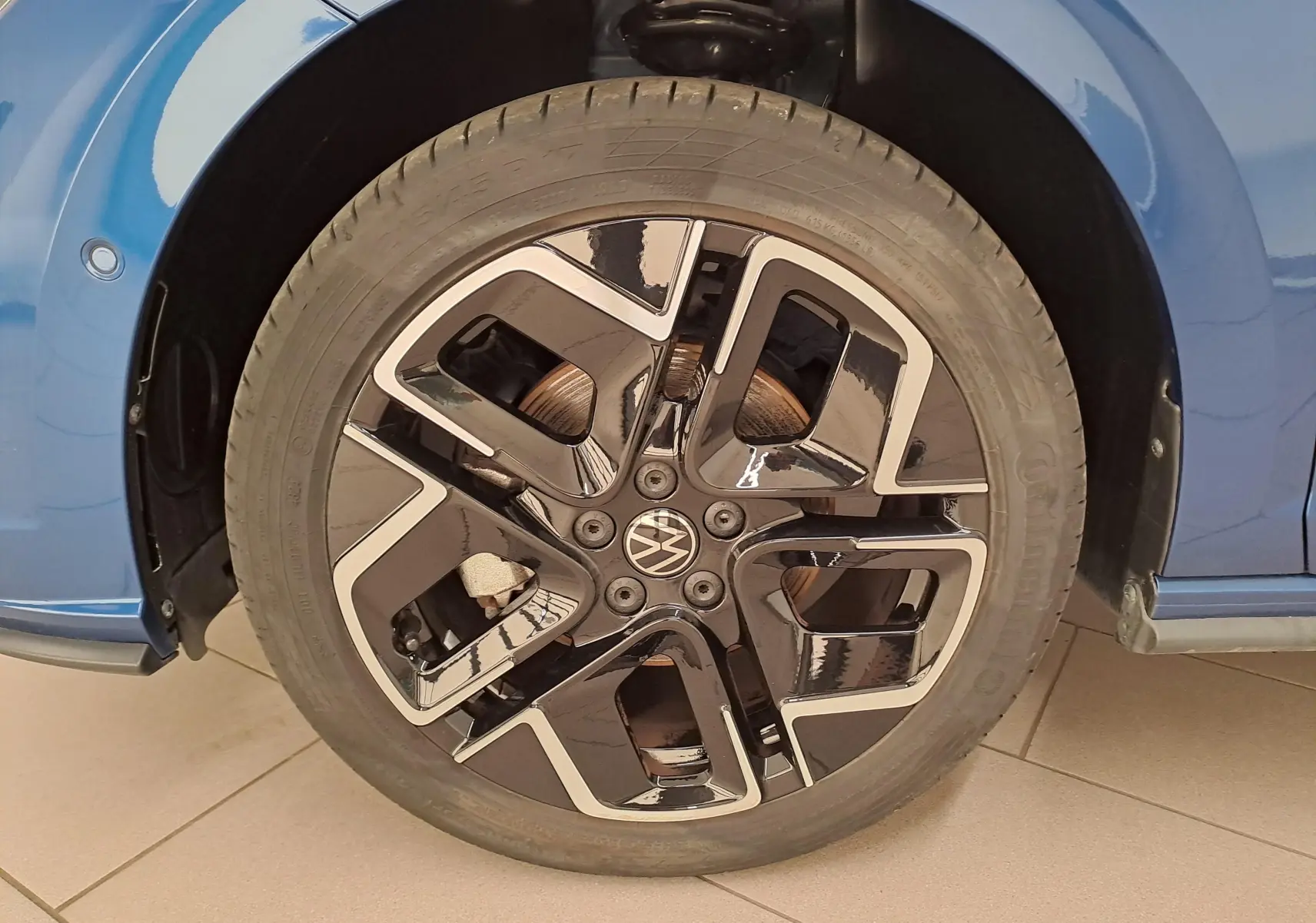 Gros plan sur la roue avant gauche de la Volkswagen Polo Bleu Récif avec jante noire et argentée R-Line.