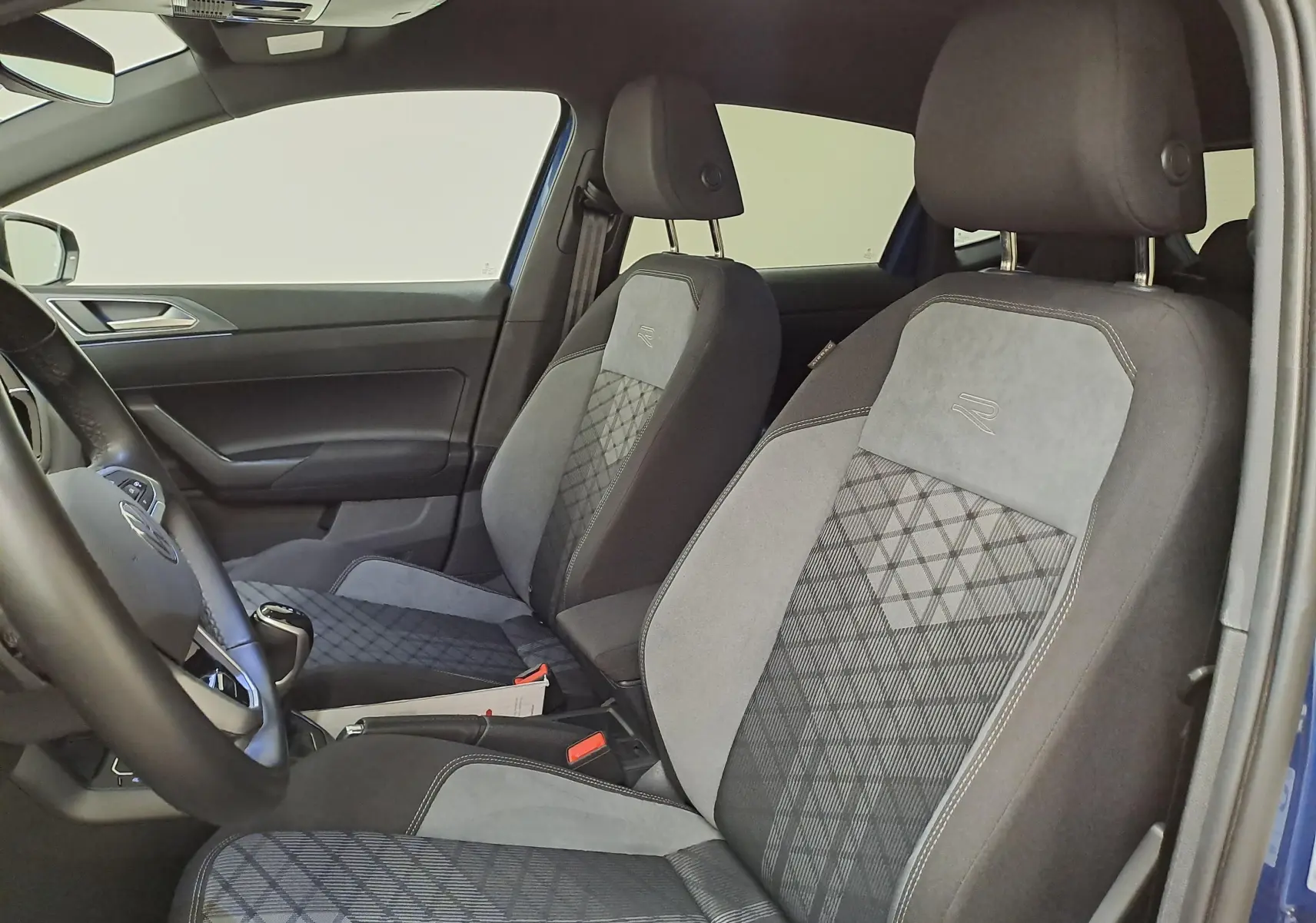 Vue intérieure côté conducteur de la Volkswagen Polo Bleu Récif, sièges sport R-Line en tissu et alcantara gris.