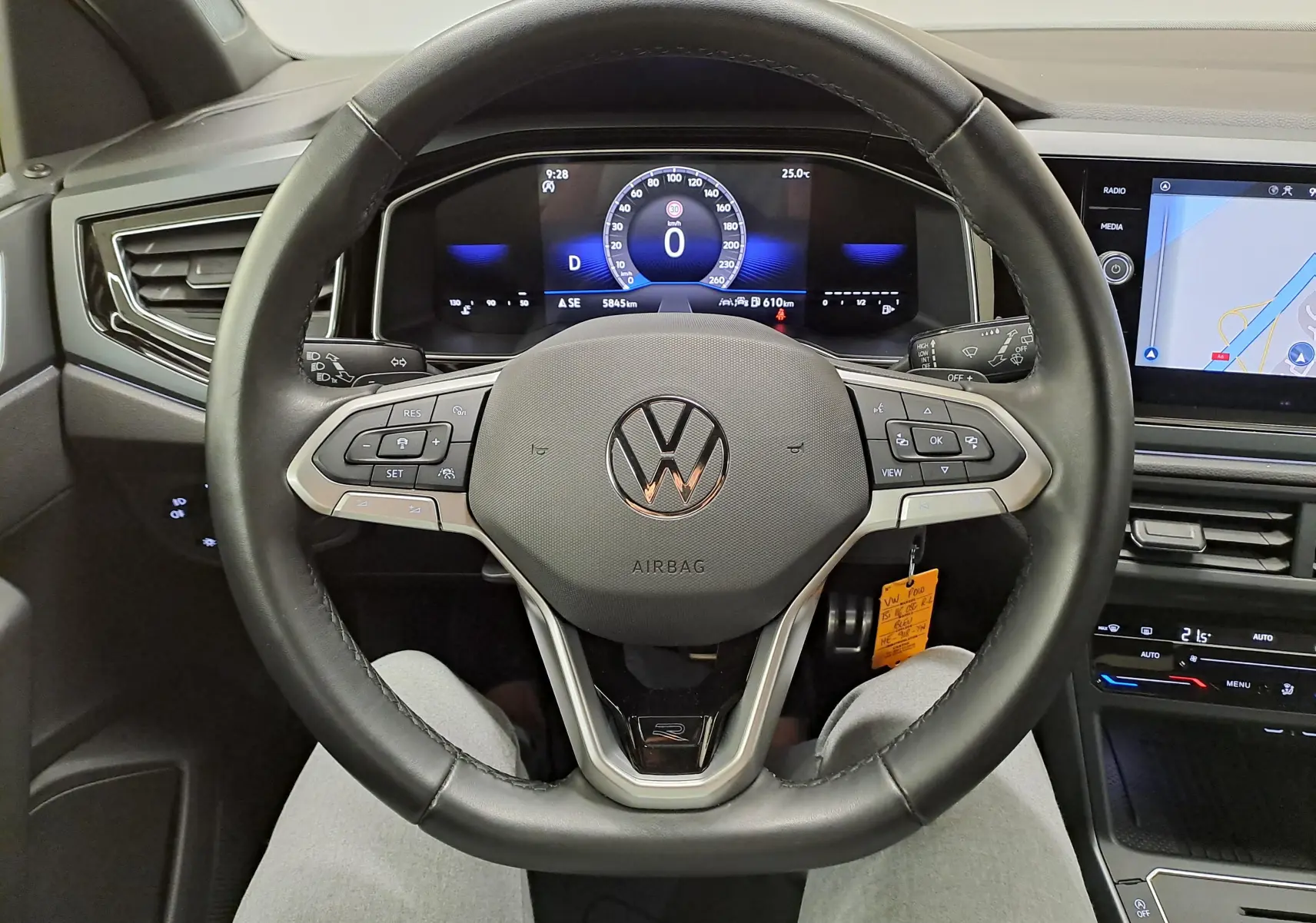 Vue intérieure centrée sur le volant cuir noir avec logo VW et tableau de bord numérique de la Volkswagen Polo 2025.