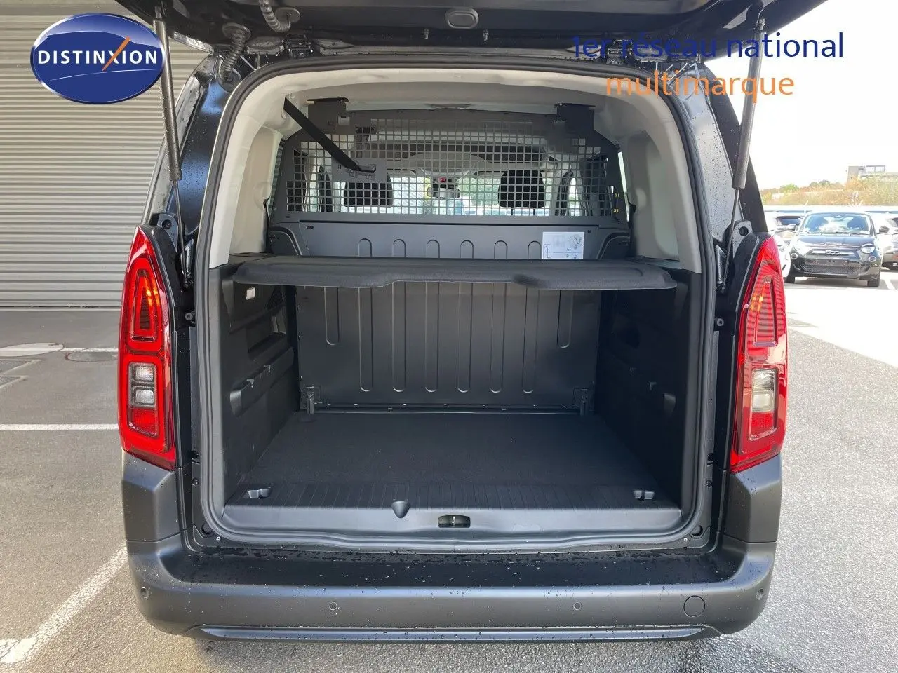 Vue arrière du Citroën Berlingo noir Perla Nera avec porte ouverte, montrant l’espace de chargement et la grille de séparation.