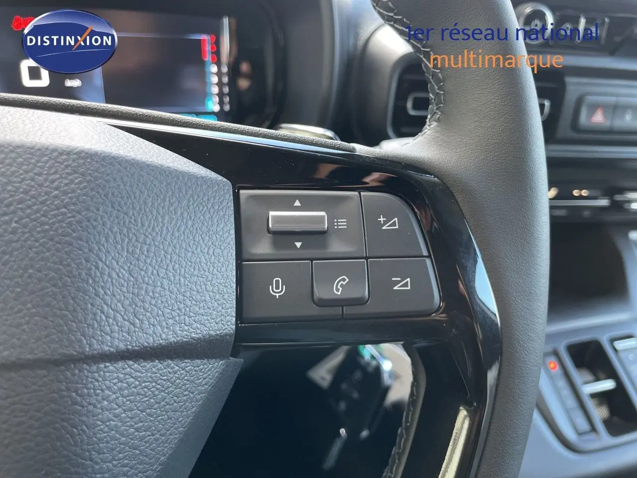 Gros plan sur les commandes au volant du Citroën Berlingo noir Perla Nera, avec tableau de bord numérique en arrière-plan.