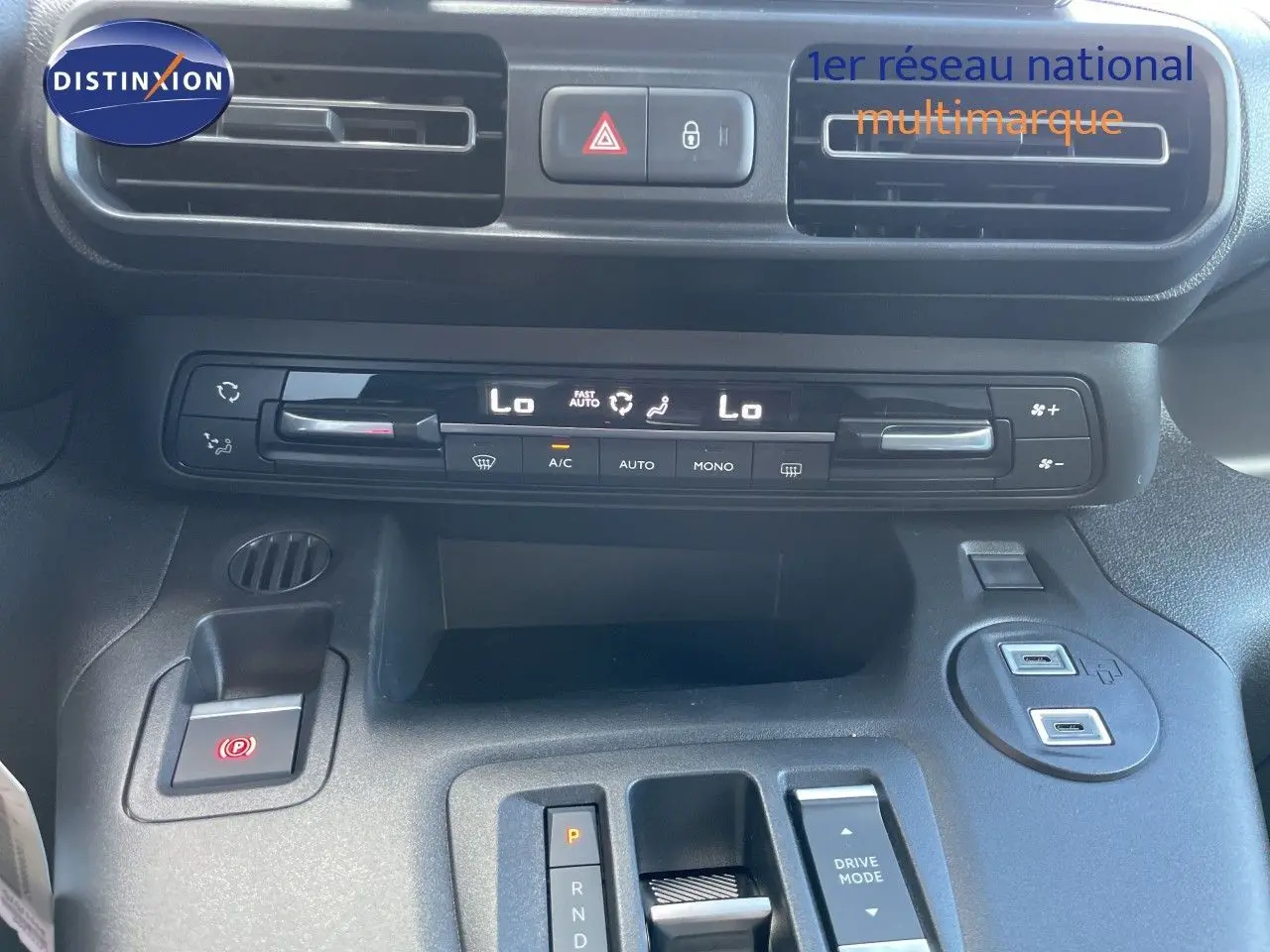 Tableau de bord et console centrale du Citroën Berlingo 2026 noir, vue rapprochée sur climatisation et commandes.