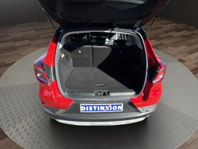 Vue arrière du Renault Captur rouge 2024 avec coffre ouvert montrant l’espace de chargement vide.