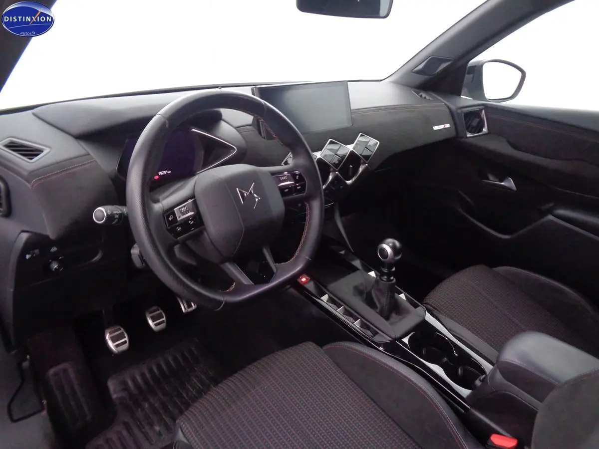 Intérieur noir du DS3 Crossback 2021 vu côté conducteur, volant compact et levier de vitesse manuel en vue rapprochée.