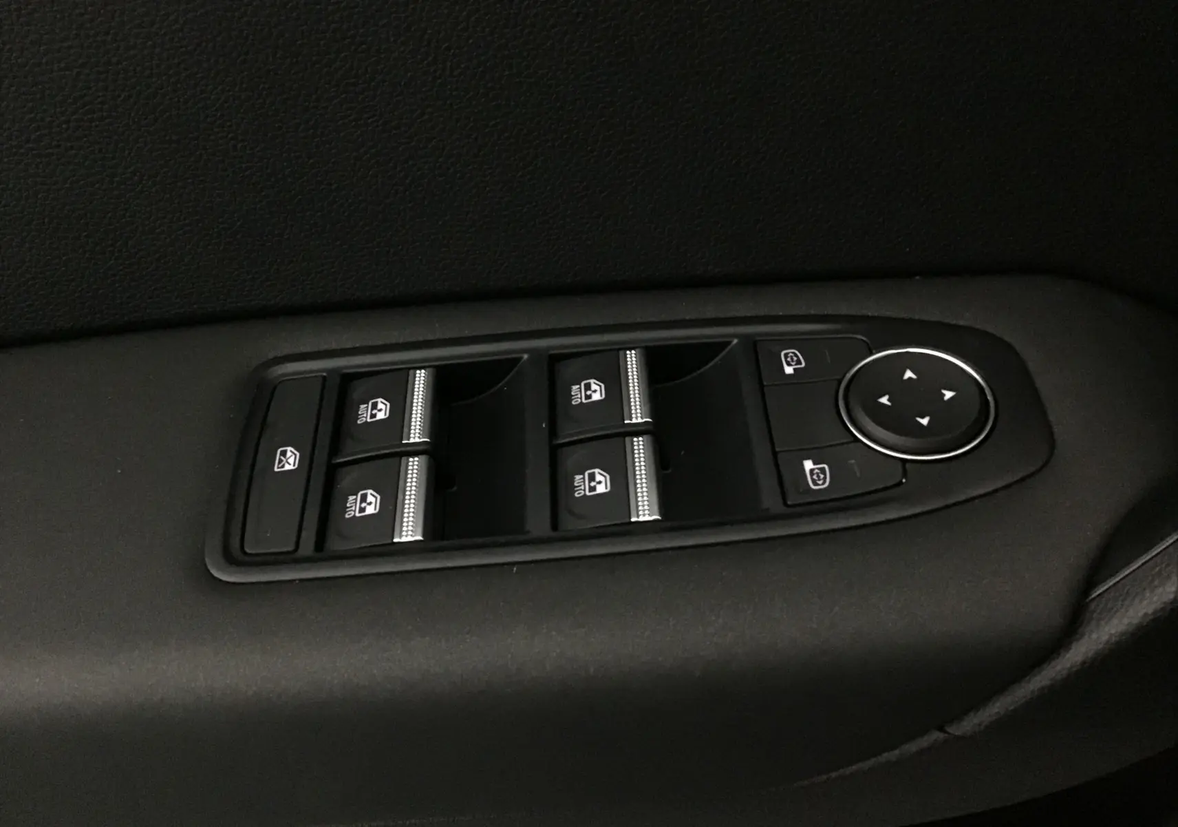 Panneau de commandes des vitres électriques et rétroviseurs sur la portière côté gauche d'un Renault Captur bleu iron/noir 2025.