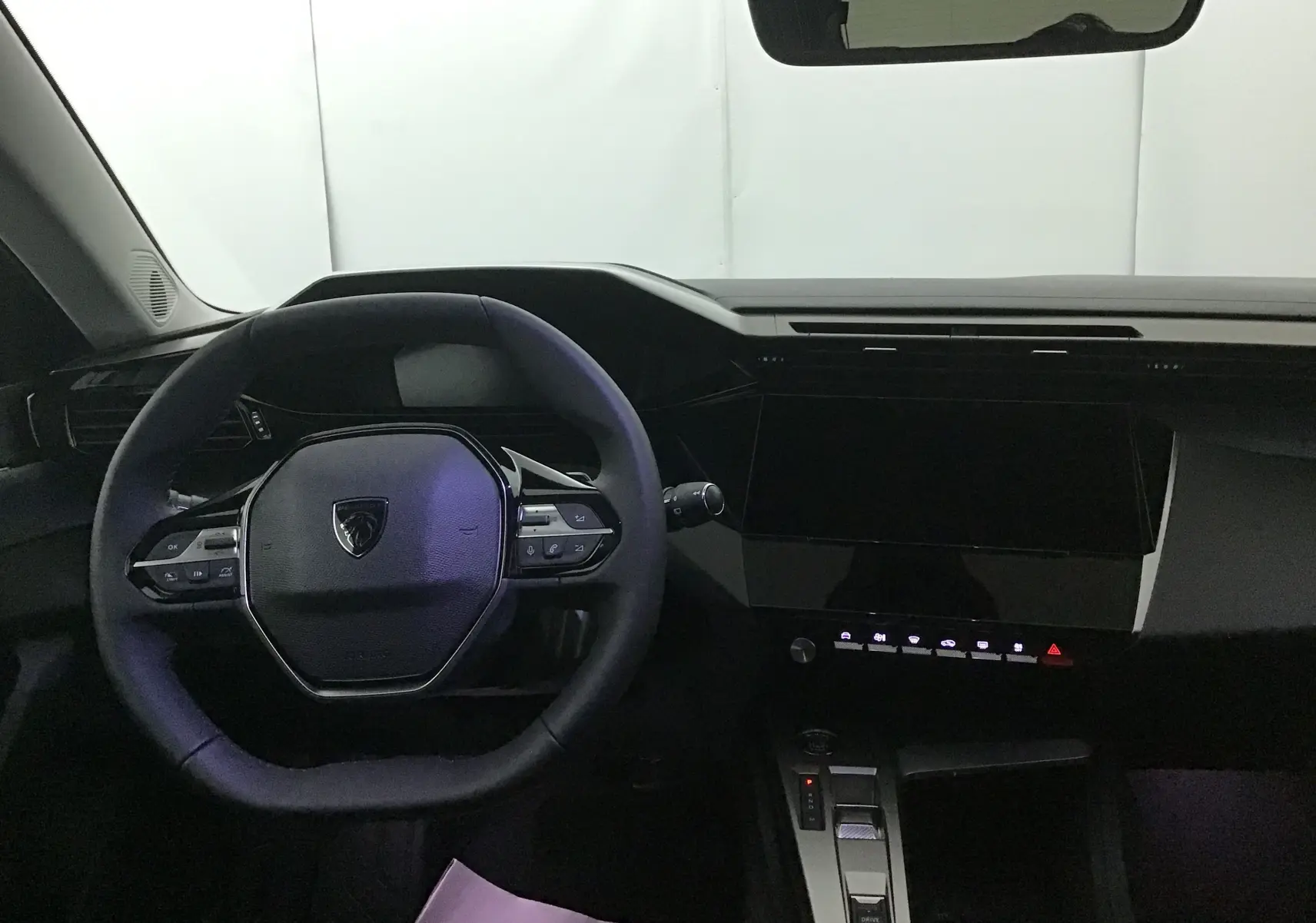 Vue intérieure du poste de conduite de la Peugeot 308 gris Artense, avec volant multifonction et tableau de bord numérique.