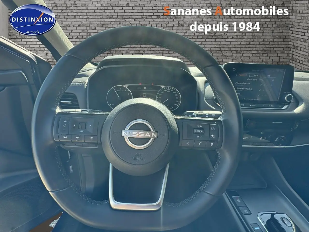 Vue rapprochée du volant multifonction noir du Nissan Qashqai 1.5 e-Power 2023 avec tableau de bord et écran tactile visible.