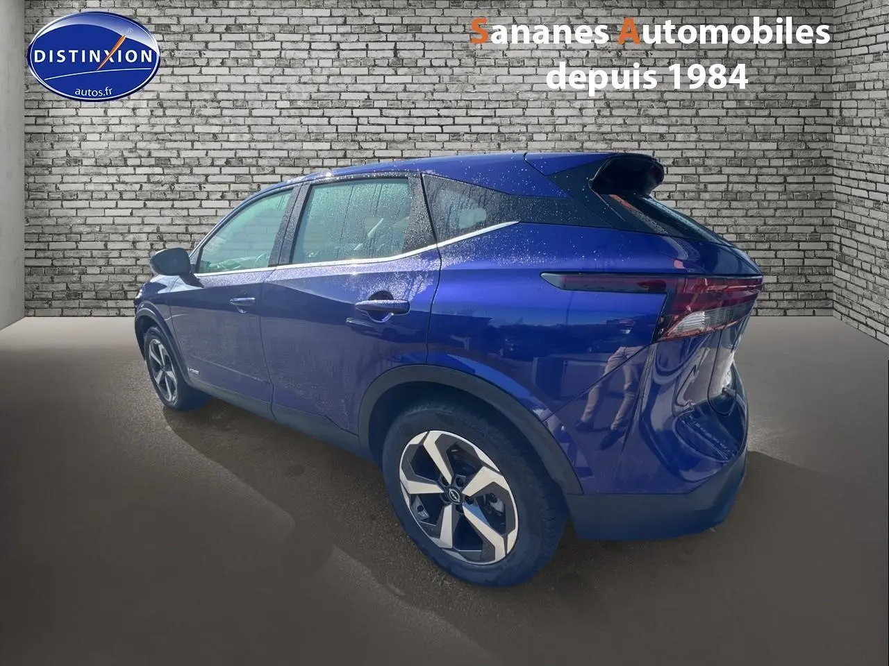 Vue 3/4 arrière gauche du Nissan Qashqai 1.5 e-Power Business Edition bleu foncé avec jantes alliage 18 pouces.