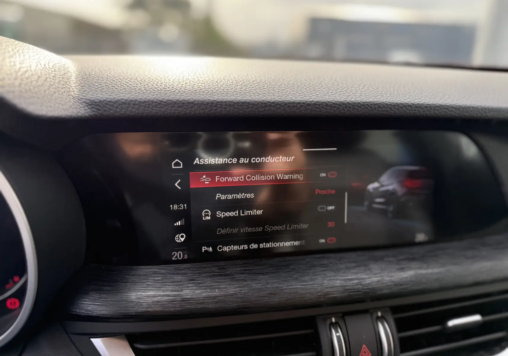 Écran central de l'Alfa Romeo Stelvio blanc 2023 affichant les options d'assistance au conducteur avec interface moderne.