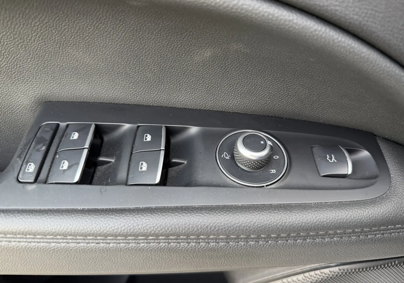 Gros plan sur les commandes de fenêtre et rétroviseurs côté gauche d'un Alfa Romeo Stelvio blanc 2023 finition Sprint.