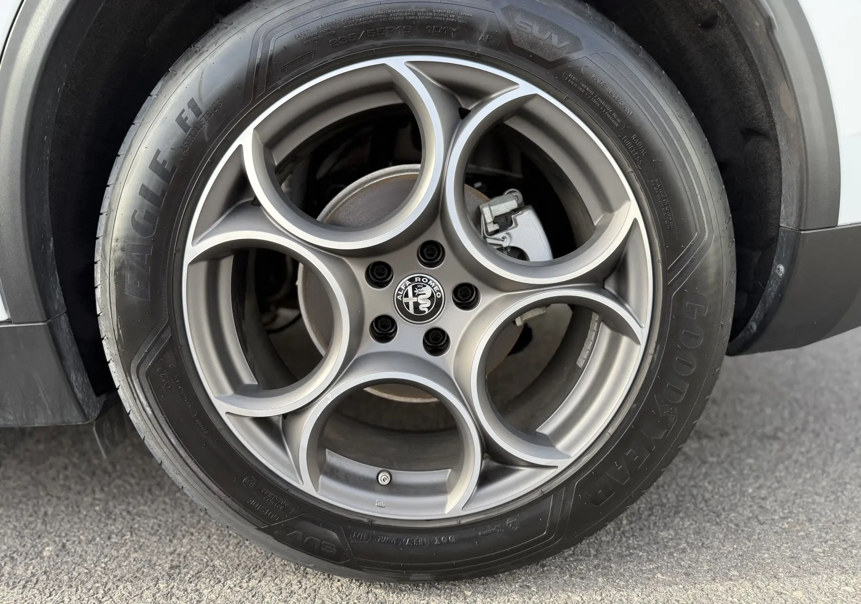 Gros plan sur la roue avant droite d'un Alfa Romeo Stelvio blanc Alfa 2023 avec pneu Goodyear Eagle.