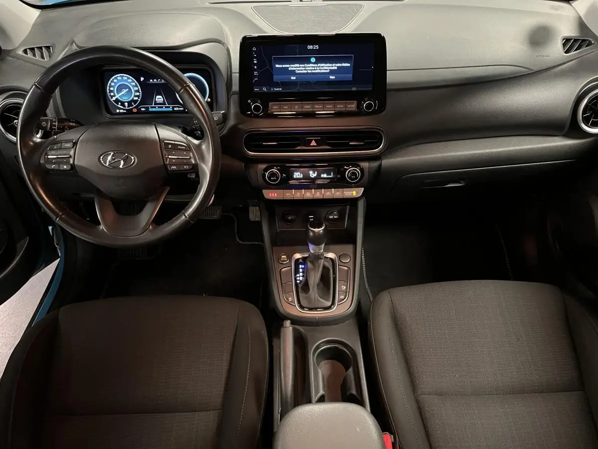 Vue intérieure avant du Hyundai Kona 1.6 CRDi Hybrid 48V avec tableau de bord numérique et écran tactile central.