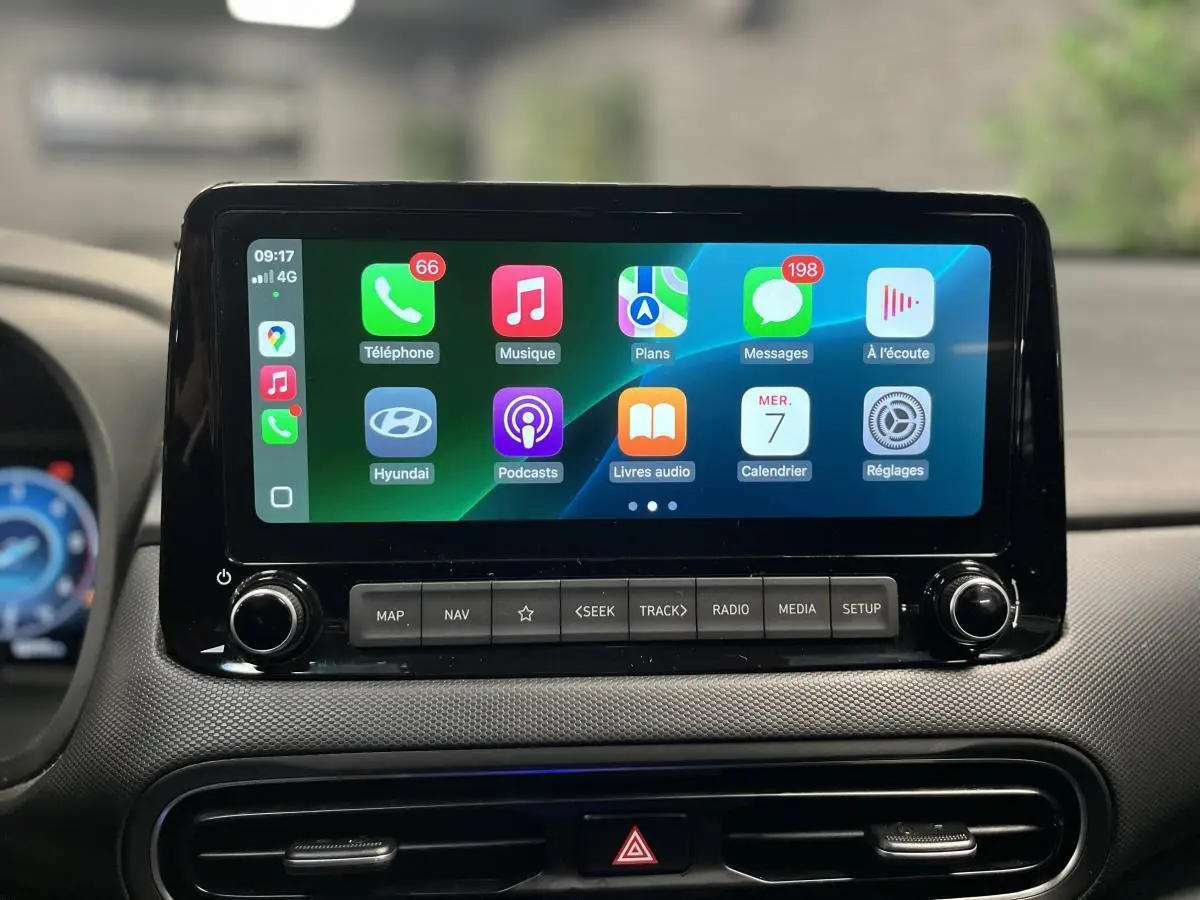 Écran tactile multimédia de la Hyundai Kona 2022 affichant Apple CarPlay avec icônes colorées, vue intérieure frontale.