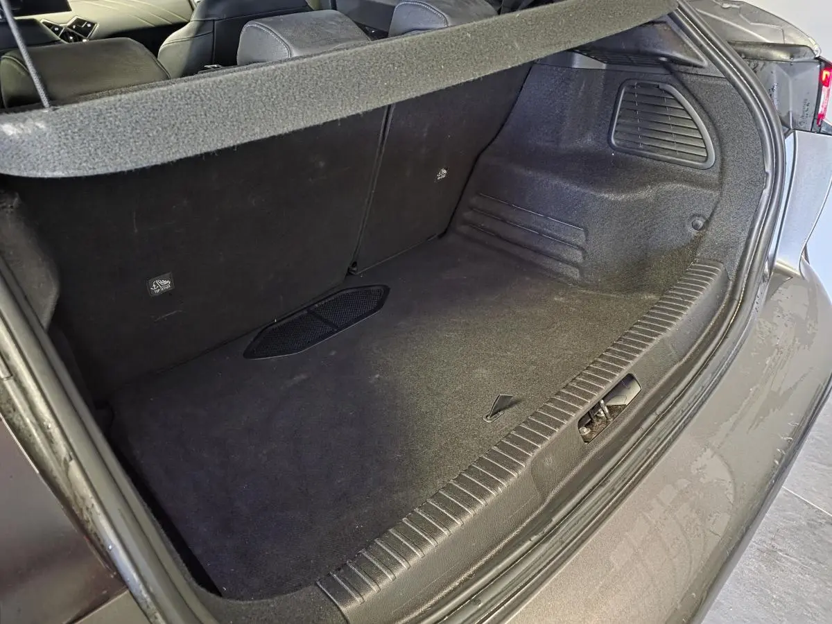 Coffre ouvert vu de trois quarts arrière droit du DS3 Crossback gris, montrant l'espace de chargement vide et les sièges arrière.