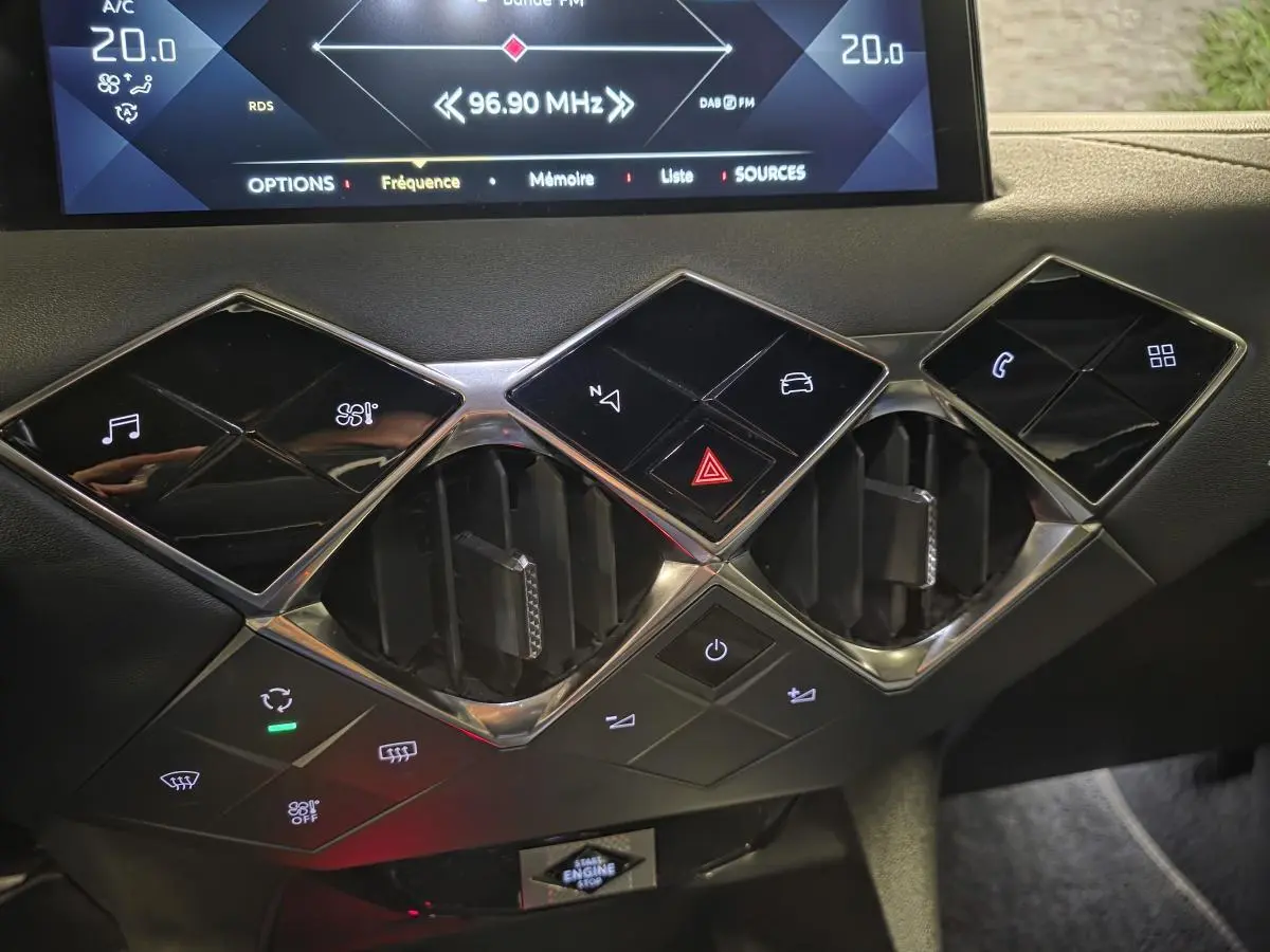Détail du tableau de bord du DS3 Crossback 2022 montrant les commandes tactiles noires et les aérateurs centraux chromés.