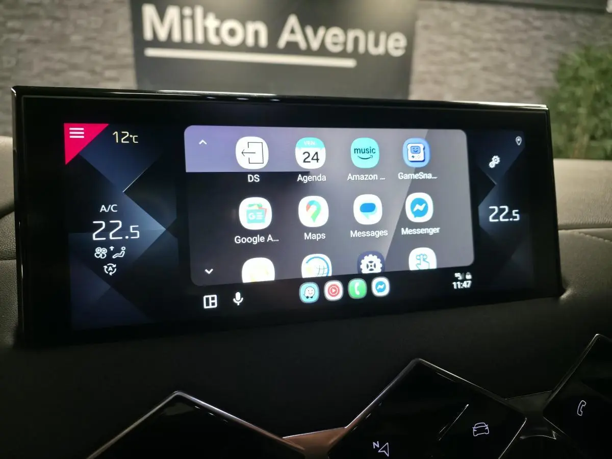 Écran tactile central du tableau de bord du DS3 Crossback gris, affichant les applications connectées et la température intérieure.
