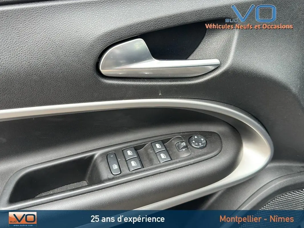 Gros plan sur la commande des vitres et rétroviseurs côté conducteur du Jeep Avenger gris foncé 2024 Altitude.