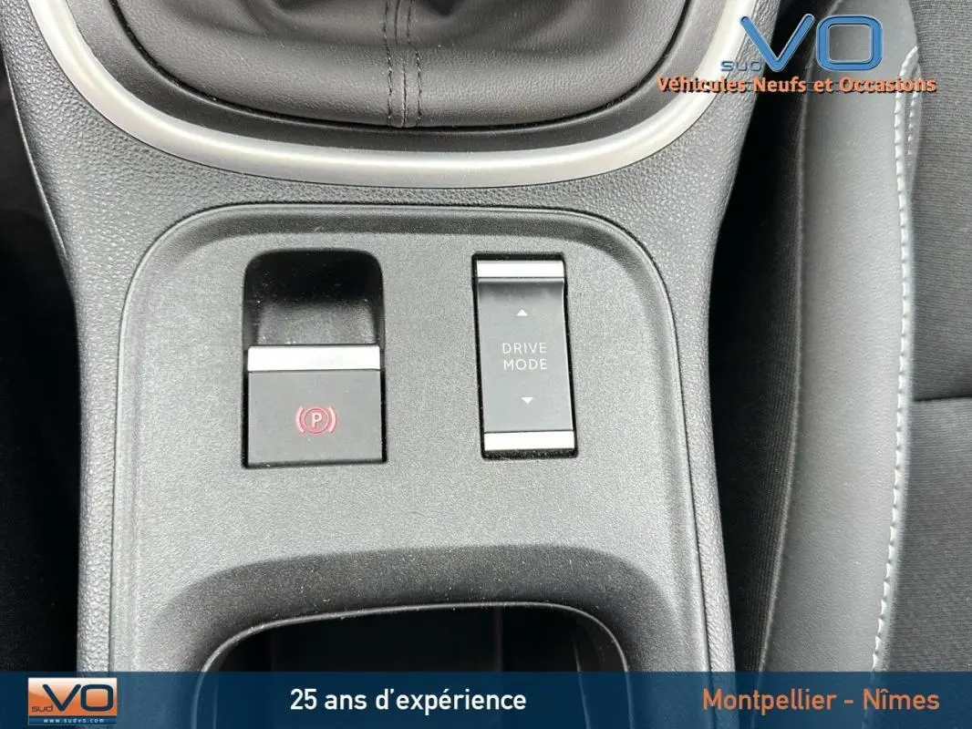 Gros plan sur la console centrale du Jeep Avenger 2024 montrant les boutons frein électronique et mode de conduite.