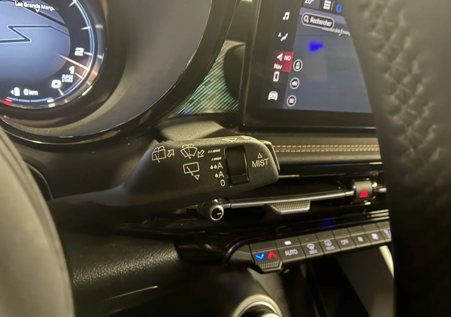 Gros plan sur la commande d’essuie-glace à gauche du volant dans l’habitacle noir de l’Alfa Romeo Tonale gris foncé 2023.