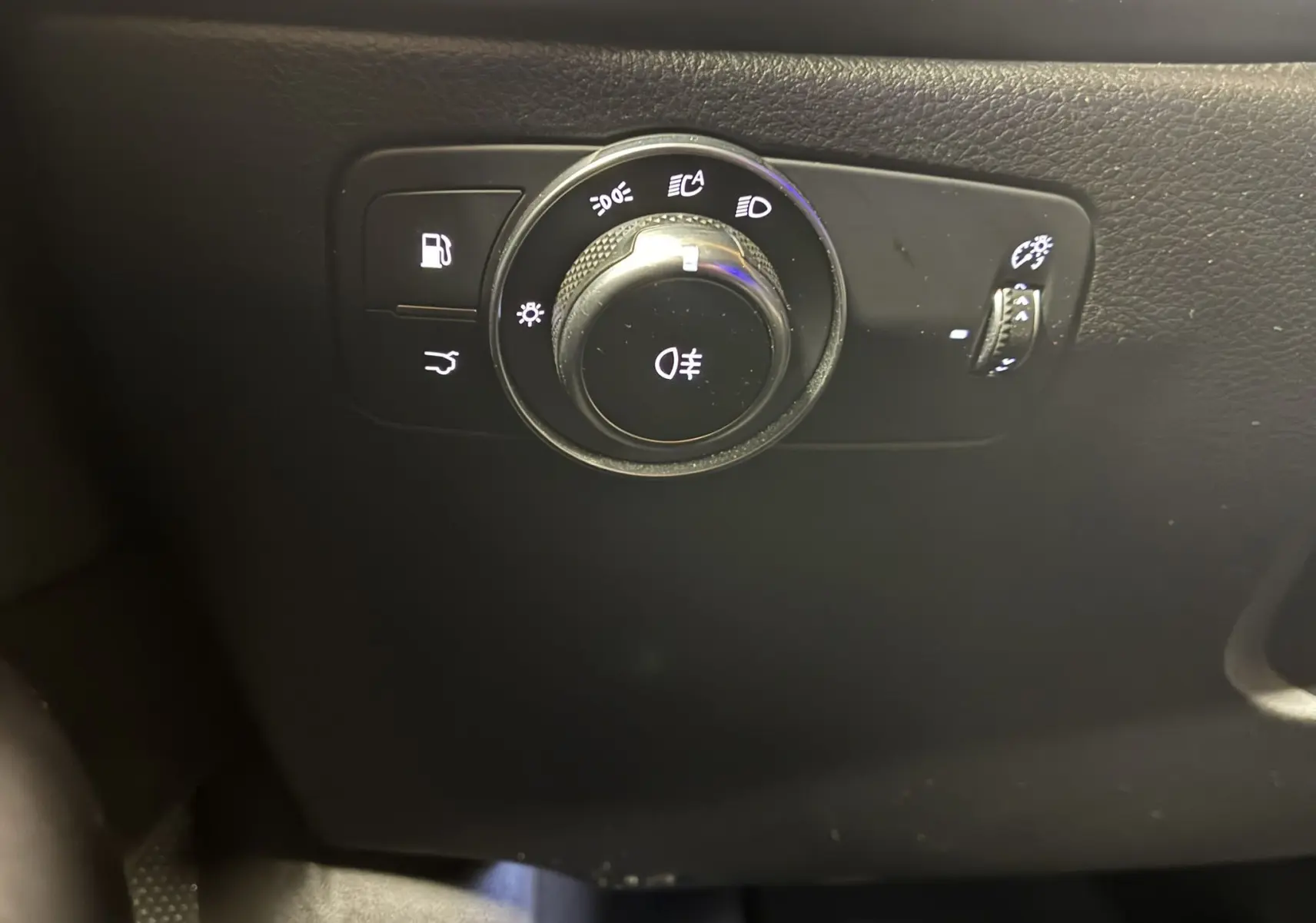 Gros plan sur le bouton de commande des phares et éclairages intérieurs noirs de l'Alfa Romeo Tonale 1.3 PHEV 280 BVA TI 2023.