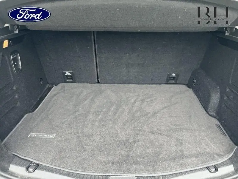 Vue intérieure du coffre spacieux d'un Renault Scénic 2022, avec tapis noir marqué "Scenic" et revêtement sombre.