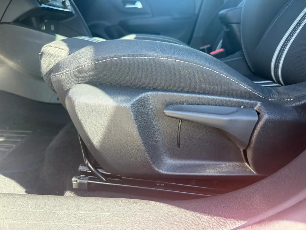 Détail de la commande de réglage manuel du siège avant droit de l’Opel Corsa rouge 2025, version 1.2 Turbo Hybrid.