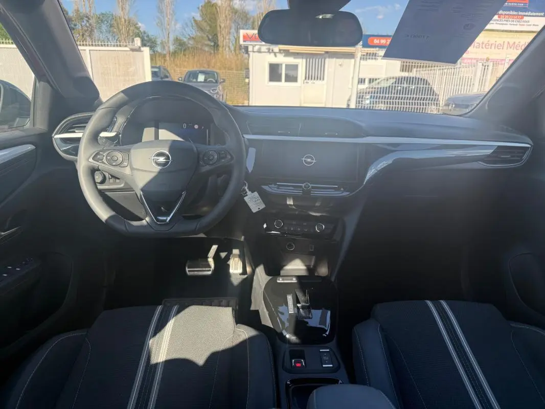 Vue intérieure avant de l’Opel Corsa 2025, tableau de bord et volant noirs avec écran central tactile.