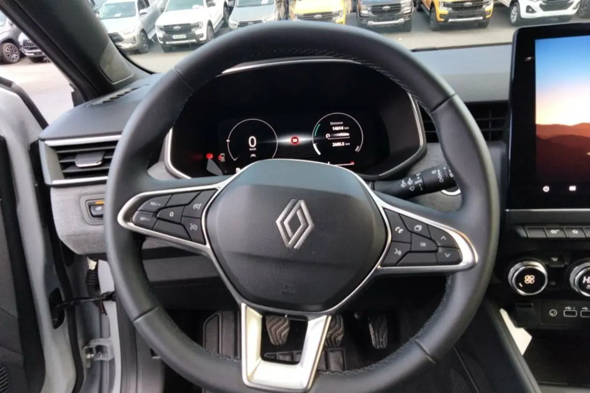 Vue rapprochée du volant cuir multifonctions et du tableau de bord numérique de la Renault Clio gris rafale 2025.