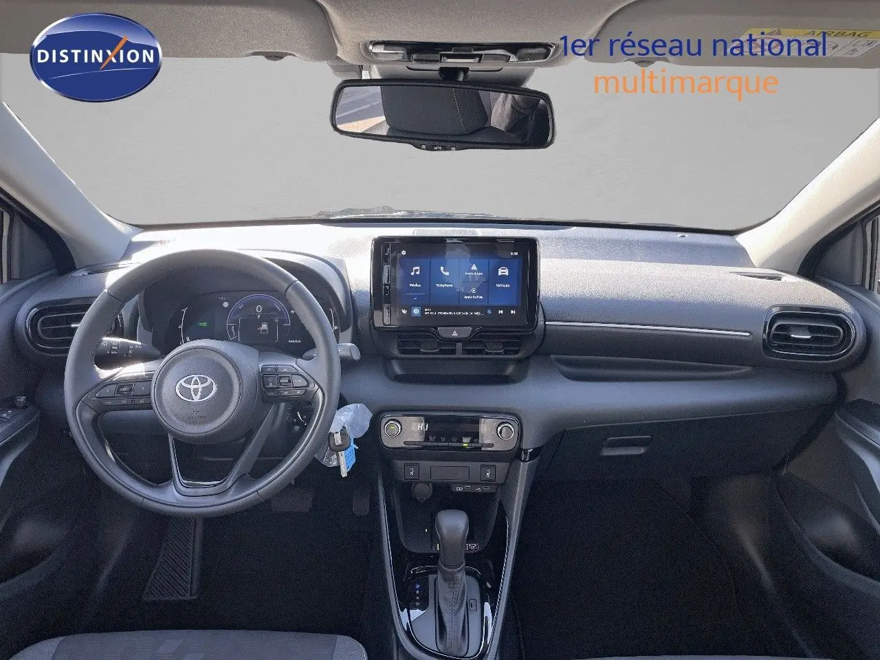 Vue frontale de l'habitacle de la Toyota Yaris Hybrid 116ch 2025, tableau de bord noir avec écran tactile central.