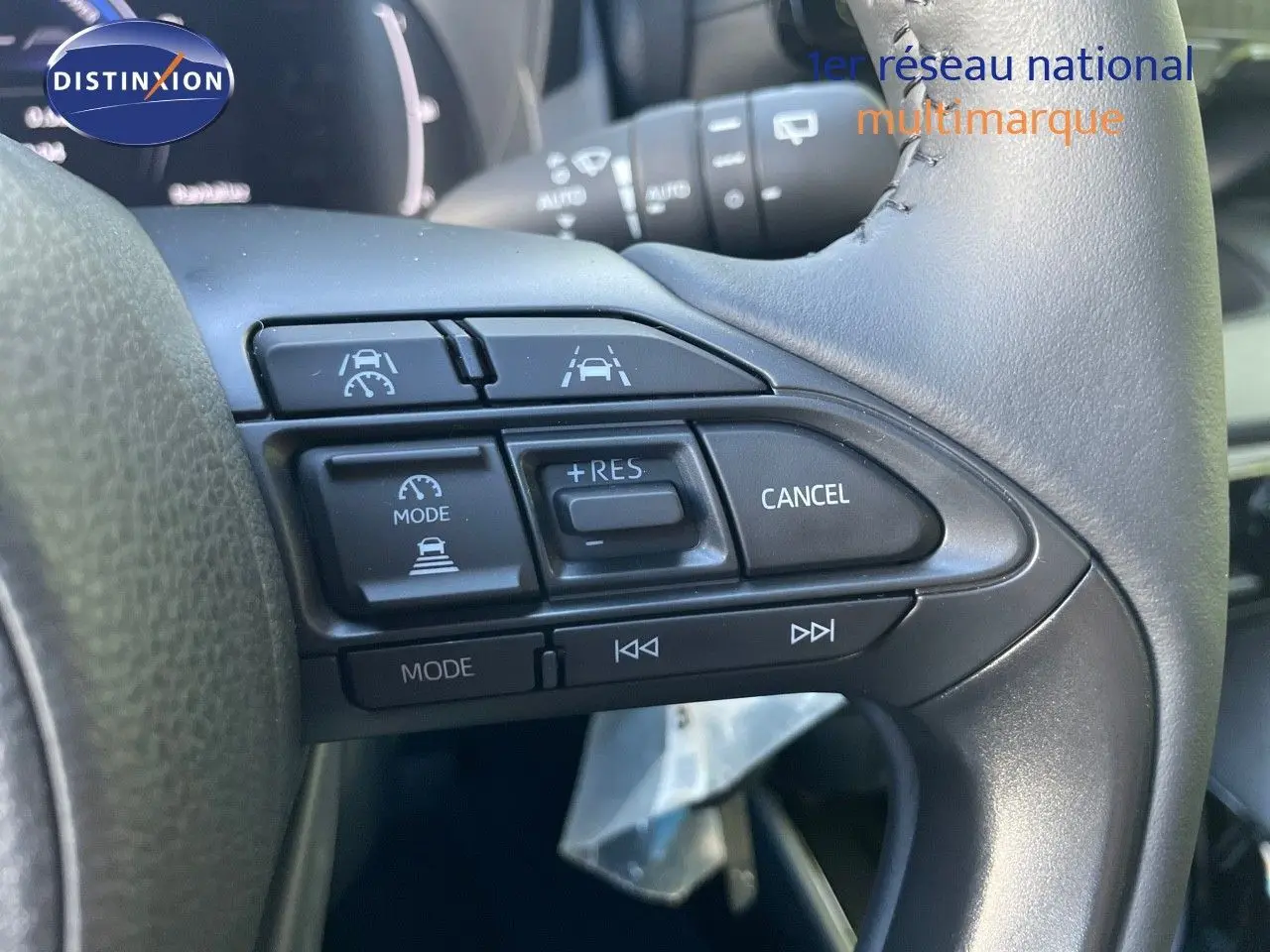 Gros plan sur les commandes au volant côté droit de la Toyota Yaris Hybrid 2025 avec finition Design en noir métal.