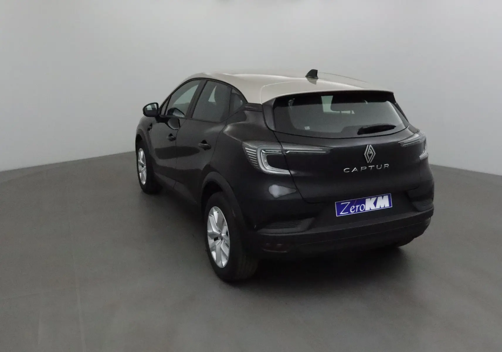 Vue 3/4 arrière gauche d'un Renault Captur 2025 noir et gris perle avec feux LED et toit contrasté.