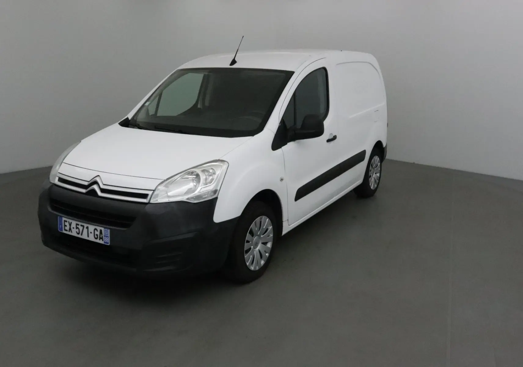 Vue 3/4 avant droit d'un utilitaire blanc Citroën Berlingo 2018 avec pare-chocs noir et jantes acier.