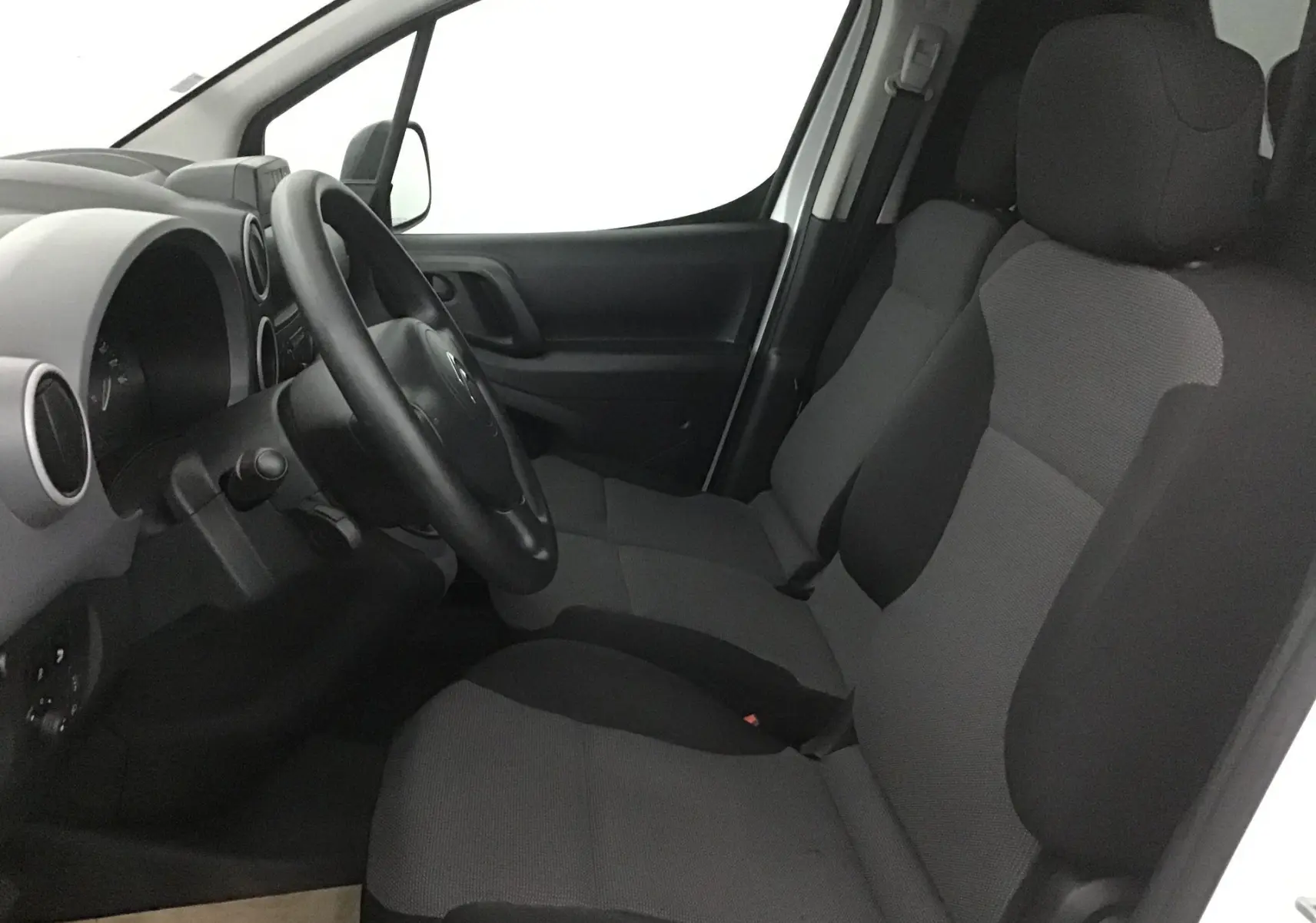 Intérieur avant droit du Citroën Berlingo blanc 2018, montrant le tableau de bord et sièges tissu gris foncé.