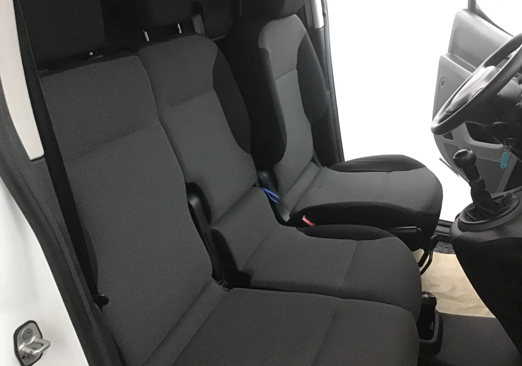 Intérieur du Citroën Berlingo blanc 2018, vue côté gauche sur les sièges avant et la boîte manuelle.